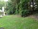 A spacious backyard with a lush lawn, mature trees, and an outdoor seating area, perfect for outdoor enjoyment at 2958 Mary Alice Trl, Loganville, GA 30052