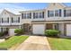 Townhome with a garage, front lawn, and a brick facade, all under a clear blue sky at 695 Georgetown Ct, Jonesboro, GA 30236