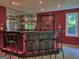 Finished basement bar area with barstools, a mirrored backdrop, and a window, ideal for entertaining guests at 307 Worthing Ln, Mcdonough, GA 30253