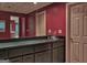 Basement wet bar features cabinetry and mirror wall with a view into the recreation room beyond at 307 Worthing Ln, Mcdonough, GA 30253