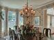Formal dining room featuring a large chandelier, windows, and floral wallpaper at 307 Worthing Ln, Mcdonough, GA 30253