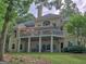 Back exterior view of the house with a covered back porch and mature landscaping on a sunny day at 307 Worthing Ln, Mcdonough, GA 30253