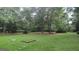 Expansive backyard features lush lawn with a picnic table nestled under mature trees creating a relaxing outdoor space at 1581 Jersey Social Circle Rd, Covington, GA 30014