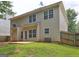 View of the backyard showing beige siding, multiple windows, and a concrete patio at 2093 Parador Bnd, Mcdonough, GA 30253