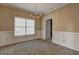 Dining room with carpet, classic chandelier, large window and beautiful white wainscoting at 2093 Parador Bnd, Mcdonough, GA 30253