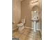 Cozy powder room with a pedestal sink, round mirror, and tiled flooring at 2093 Parador Bnd, Mcdonough, GA 30253
