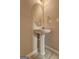Powder room featuring pedestal sink, round mirror, and soft neutral tones at 2093 Parador Bnd, Mcdonough, GA 30253