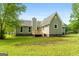 Back exterior of a gray home featuring a deck, a chimney, and a well-kept lawn at 106 June Ct, Hampton, GA 30228