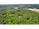 Expansive aerial view reveals a private home nestled in lush greenery and mature trees at 285 Spear Rd, Peachtree City, GA 30269