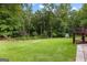 Green backyard is surrounded by lush trees with a partial view of a garden shed at 285 Spear Rd, Peachtree City, GA 30269