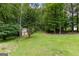 Scenic backyard with a storage shed surrounded by mature trees, offering a private outdoor retreat at 285 Spear Rd, Peachtree City, GA 30269