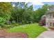 Well-manicured backyard featuring lush green lawn, mature trees, and space for gardening or recreation at 285 Spear Rd, Peachtree City, GA 30269