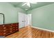 Bedroom with green walls, ceiling fan, hardwood floors and trim, and double closet at 285 Spear Rd, Peachtree City, GA 30269