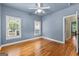 Bedroom with blue walls, hardwood flooring, ceiling fan, and multiple windows at 285 Spear Rd, Peachtree City, GA 30269