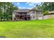 Back exterior featuring an expansive deck, a well-maintained lawn, and an attached garage at 285 Spear Rd, Peachtree City, GA 30269
