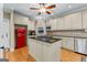 Spacious kitchen featuring a granite island cooktop, tiled backsplash, stainless appliances, and a retro red refrigerator at 285 Spear Rd, Peachtree City, GA 30269