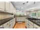 Bright kitchen with an island cooktop, granite counters, tiled backsplash, stainless appliances, and wood flooring at 285 Spear Rd, Peachtree City, GA 30269