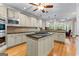 Open-concept kitchen boasts granite countertops, tiled backsplash, built-in appliances, and a large island cooktop at 285 Spear Rd, Peachtree City, GA 30269