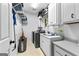 Well-equipped laundry room with white cabinetry, utility sink, storage shelving, and modern washer and dryer at 285 Spear Rd, Peachtree City, GA 30269