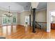 Open-concept living room featuring wood floors, chandelier, staircase, and decorative columns at 285 Spear Rd, Peachtree City, GA 30269