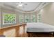 Main bedroom with tray ceiling, ceiling fan, many windows, and hardwood flooring at 285 Spear Rd, Peachtree City, GA 30269