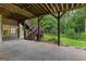 Covered patio features wooden beams and easy access to stairs leading to the lush, green backyard at 285 Spear Rd, Peachtree City, GA 30269