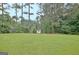 Large backyard with green grass and a small storage shed in a private, wooded setting at 550 Hawthorne Dr, Fayetteville, GA 30214