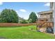 Large, fenced backyard with lush green lawn, patio, deck, and mature trees for privacy and outdoor activities at 910 Pebble Creek Trl, Suwanee, GA 30024
