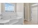 Bright bathroom with a white tub and shower featuring a tiled backsplash and a large window at 910 Pebble Creek Trl, Suwanee, GA 30024