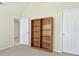 Bedroom with neutral carpet has a closet with a wooden bookshelf at 910 Pebble Creek Trl, Suwanee, GA 30024