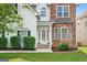 Elegant entryway with a glass-paneled front door, manicured bushes, and stylish stone detailing at 910 Pebble Creek Trl, Suwanee, GA 30024
