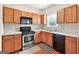 Functional kitchen with wood cabinets, modern appliances, and practical layout for cooking convenience at 910 Pebble Creek Trl, Suwanee, GA 30024