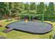 Community playground featuring a swingset surrounded by mature trees and lush landscaping at 910 Pebble Creek Trl, Suwanee, GA 30024