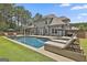 Inviting backyard oasis featuring a sparkling pool, lounge chairs, and a beautifully landscaped lawn at 33 Vinery Ct, Sharpsburg, GA 30277