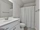 Bright bathroom showcases a white vanity, mirror, and shower/toilet room featuring tiled floors at 33 Vinery Ct, Sharpsburg, GA 30277