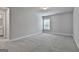 Spacious carpeted bedroom with a large window and neutral walls leading into the en suite bathroom at 33 Vinery Ct, Sharpsburg, GA 30277