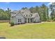 Well-maintained home featuring gray siding, stone detailing, and a professionally landscaped lawn at 33 Vinery Ct, Sharpsburg, GA 30277