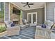 Cozy covered patio featuring a stone fireplace, comfortable seating, and a ceiling fan for relaxed outdoor living at 33 Vinery Ct, Sharpsburg, GA 30277