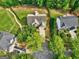 Overhead shot of a landscaped property featuring a two-story house, driveway, and mature trees at 1132 Hargrove Ct, Locust Grove, GA 30248