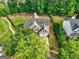 Aerial view of a home with a large yard surrounded by lush greenery, featuring a two-car garage at 1132 Hargrove Ct, Locust Grove, GA 30248