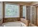 Beautiful bathroom featuring a jetted tub, glass shower, and large window at 1132 Hargrove Ct, Locust Grove, GA 30248