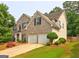 Attractive brick and siding home with a two-car garage and well-manicured front yard at 1132 Hargrove Ct, Locust Grove, GA 30248