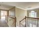 Upstairs hallway landing with wood railing and trim details and natural light at 1132 Hargrove Ct, Locust Grove, GA 30248