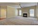 Living room with fireplace, ceiling fan, and large windows overlooking yard at 1132 Hargrove Ct, Locust Grove, GA 30248