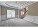 Bright living room with neutral walls, white trim, carpet flooring, and large front window at 1132 Hargrove Ct, Locust Grove, GA 30248