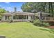 Expansive backyard with a screen porch, wooden deck and patio area bordered by lush flower beds and landscaping at 505 Bracken Edge, Peachtree City, GA 30269