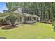 Exterior view showcasing the home, deck, and backyard, featuring lush lawn and mature trees at 505 Bracken Edge, Peachtree City, GA 30269