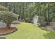 Manicured backyard featuring a storage shed and lush lawn surrounded by mature trees for privacy at 505 Bracken Edge, Peachtree City, GA 30269