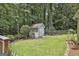 Backyard featuring a storage shed, lush lawn, and mature trees, creating a private and serene outdoor space at 505 Bracken Edge, Peachtree City, GA 30269