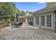 Home's exterior showcasing a wooden deck, an awning, and a grill, all set against a backdrop of mature trees at 505 Bracken Edge, Peachtree City, GA 30269